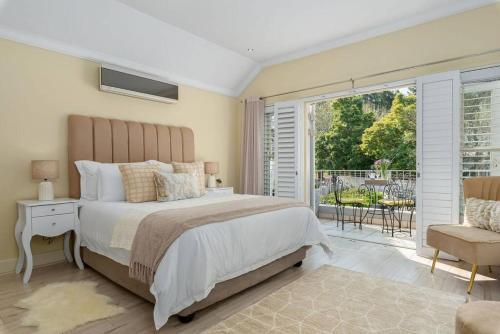 a bedroom with a large bed and a balcony at The Tram Home Stay in Franschhoek