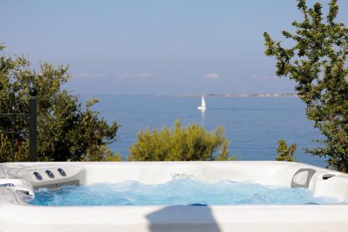 a bath tub filled with water next to the ocean at Avra Private Suites in Lassi