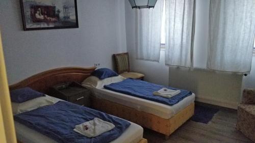 1 dormitorio con 2 camas y ventana en Öregház vendégház, en Lakhegy