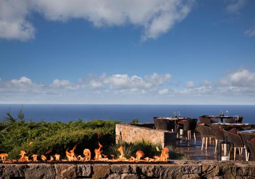 a fire pit with a table and chairs and the ocean at Alila Ventana Big Sur - Inclusive Resort in Big Sur