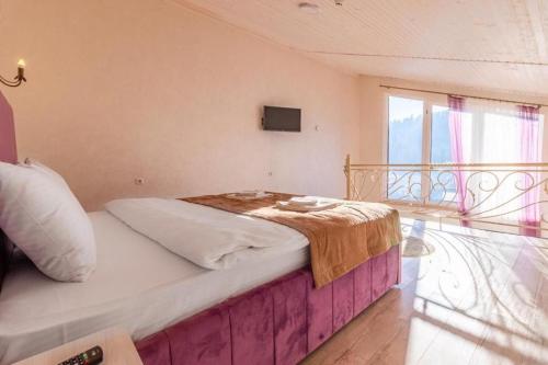 a bedroom with a large bed with a window at Gold Palace SPA Resort Bukovel in Bukovel