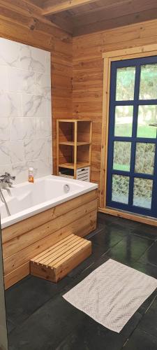 une grande baignoire dans une pièce avec une fenêtre dans l'établissement Adorable petit châlet près de la forêt et des commerces, à Montivilliers