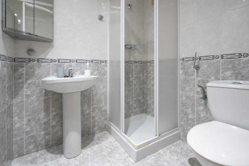 a bathroom with a shower and a toilet and a sink at Urbanización Bulevar Playa in Benimagrell