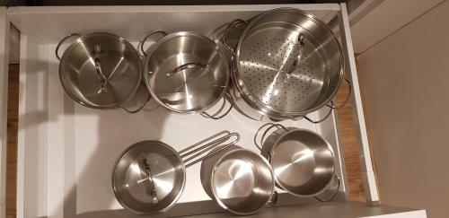a bunch of metal pots and pans in a drawer at AppPrusnik in Ljubljana