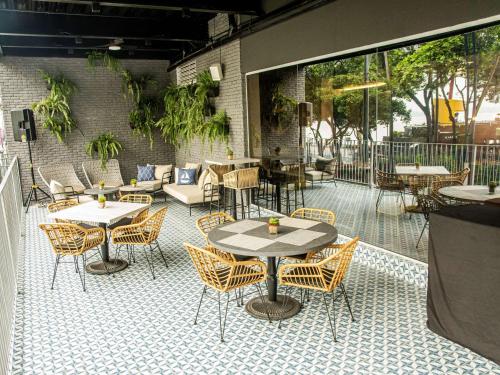 a patio with tables and chairs on a tiled floor at Ibis Styles El Malecon Guayaquil in Guayaquil