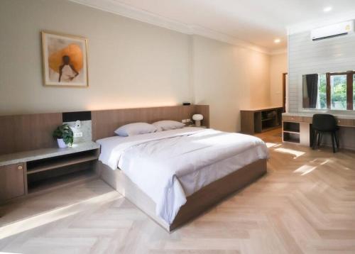 une chambre avec un grand lit et un bureau dans l'établissement Chamber’ 64 private pool villa, à Chiang Mai