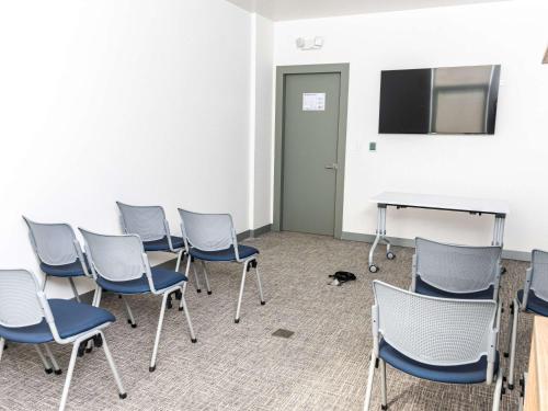 a room with chairs and a table and a tv at Ibis Styles El Malecon Guayaquil in Guayaquil