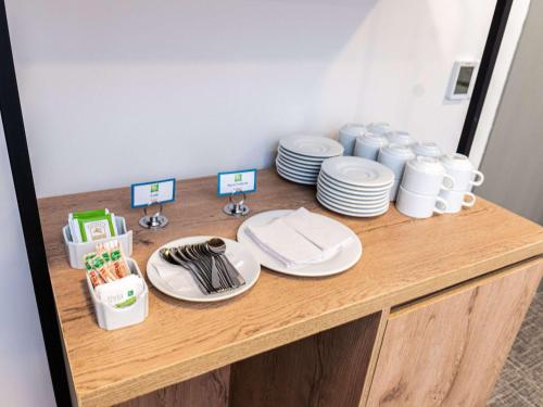 a wooden counter with plates and dishes on it at Ibis Styles El Malecon Guayaquil in Guayaquil
