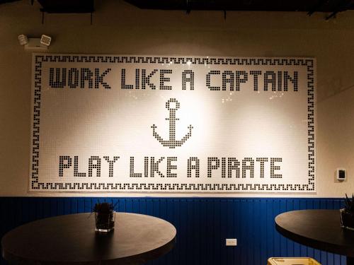 a wall with a sign that says whine like a captain hop like a pirate at Ibis Styles El Malecon Guayaquil in Guayaquil