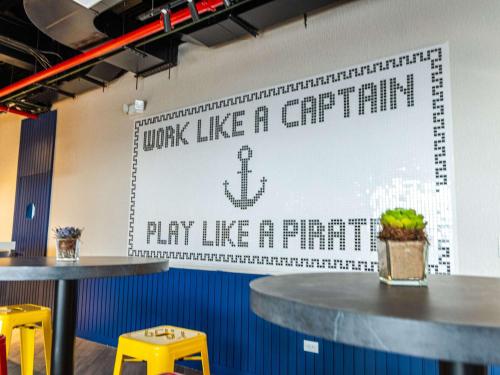 a wall with a sign that saysplay like a captain pay like a pirate at Ibis Styles El Malecon Guayaquil in Guayaquil