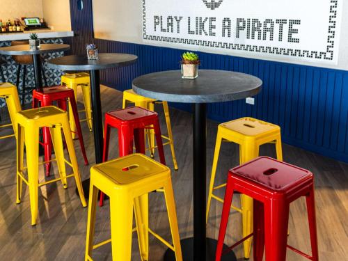 a group of colorful tables and stools in a restaurant at Ibis Styles El Malecon Guayaquil in Guayaquil