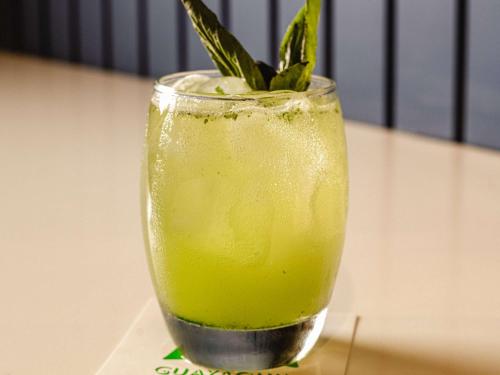 a glass with a green drink with a plant in it at Ibis Styles El Malecon Guayaquil in Guayaquil