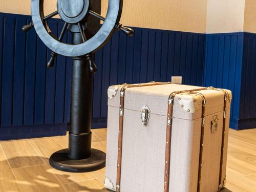 a suitcase sitting next to a fan and a wheel at Ibis Styles El Malecon Guayaquil in Guayaquil