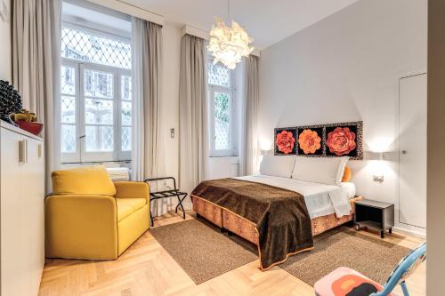 a bedroom with a bed and a yellow chair at La Corte Di Partenope Napoli in Naples