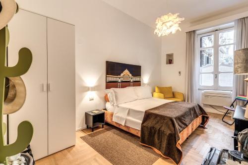 a bedroom with a bed and a yellow chair at La Corte Di Partenope in Naples