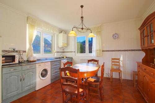 uma cozinha com uma mesa e cadeiras numa cozinha em Villa La Palmera em Mortera