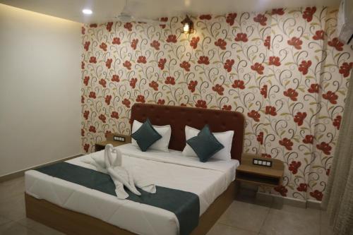 a bedroom with a bed with a flowery wallpaper at The Sky Comfort Beach Hotel, Dwarka in Dwarka