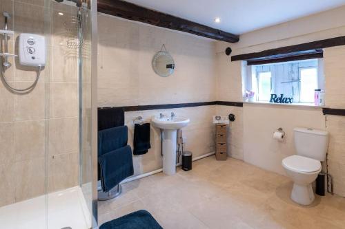 a bathroom with a toilet and a sink and a shower at The Old Hay Barn - Games Room, Gym, Sleeps 8 in Godmanchester