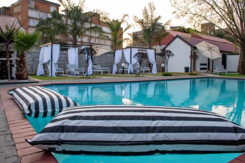a swimming pool with two pillows on the side at Ditoro Boutique Hotel in Pretoria