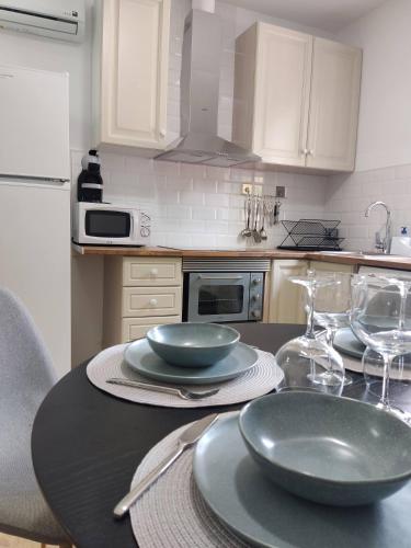 eine Küche mit einem Tisch mit Tellern und Gläsern darauf in der Unterkunft Apartamento delux2 in Valencia