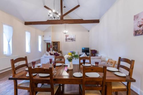 a dining room and living room with a table and chairs at The Old Hay Barn - Games Room, Gym, Sleeps 8 in Godmanchester
