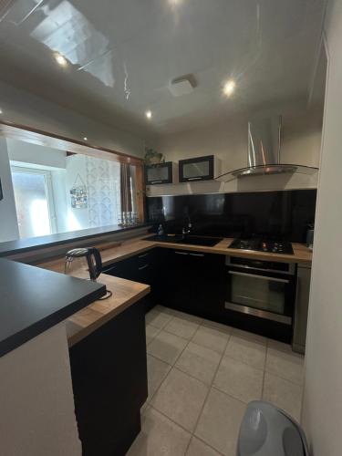 a kitchen with black cabinets and a stove top oven at La Maisonnette in Les Pieux
