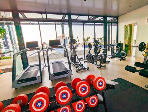 a gym with lots of exercise equipment and red barbells at Lovina 1615 at Pollux Meisterstadt in Batam Center
