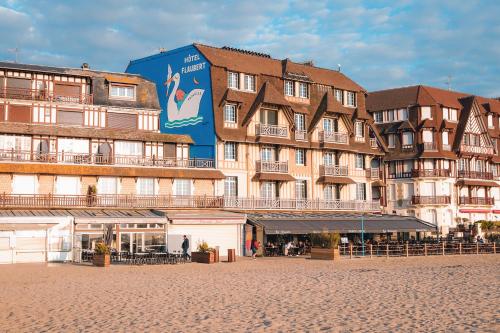 a large building on the beach in front of a building at Le Flaubert in Trouville-sur-Mer