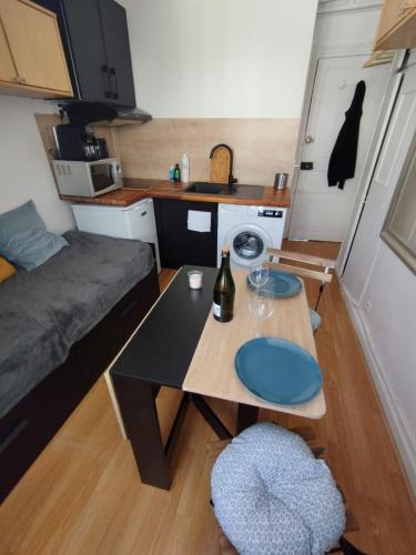 un petit salon avec une table et un canapé dans l'établissement Cosy Studio village of Batignolles, à Paris