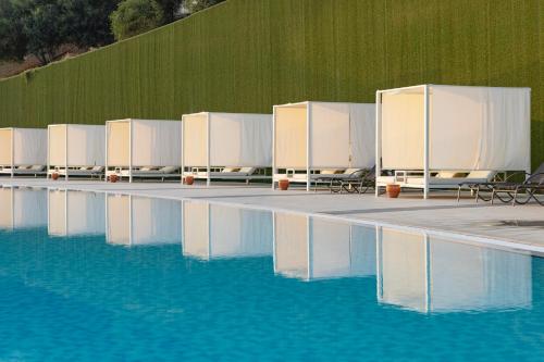 a pool of water with chairs and mirrors in it at Elexus Hotel Resort & Spa & Casino in Kérynia