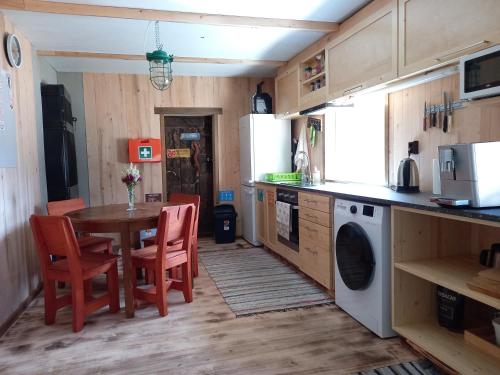 a kitchen with a table and a table and chairs at Vastseliina Metskond Camping in Vahtseliina