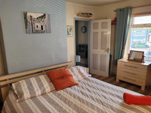 a bedroom with a bed with orange pillows on it at No 27 Guisborough - 1 bed apartment in Guisborough