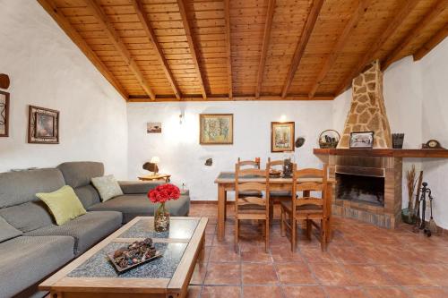 a living room with a couch and a table and a fireplace at El Lagar in Icod de los Vinos