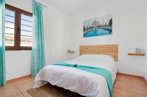 a bedroom with a bed with a picture on the wall at Villa Baobab in Corralejo