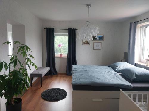 een slaapkamer met een bed en een potplant bij Haus am Seidelberg in Dürrhennersdorf