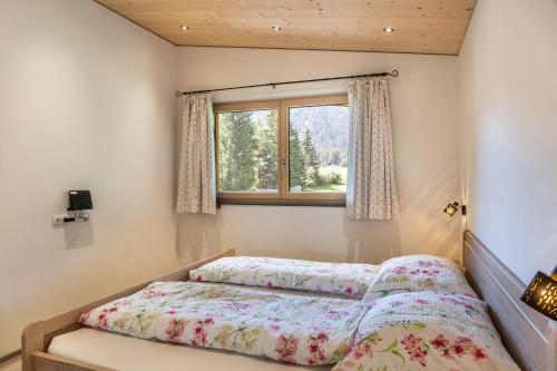 1 dormitorio con cama y ventana en Rehwiese en Obernberg am Brenner