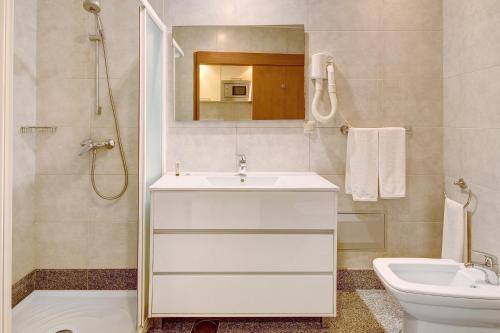 ein Badezimmer mit Waschbecken, Toilette und Spiegel in der Unterkunft Dfm Happy Days F - Funchal in Funchal