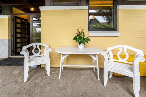 two chairs and a table with a vase of flowers on a patio at Ferienwohnung 2 in Damp