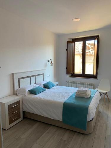 a bedroom with a large bed and a window at Apartamentos Rurales La Plaza 2 in Duruelo de la Sierra