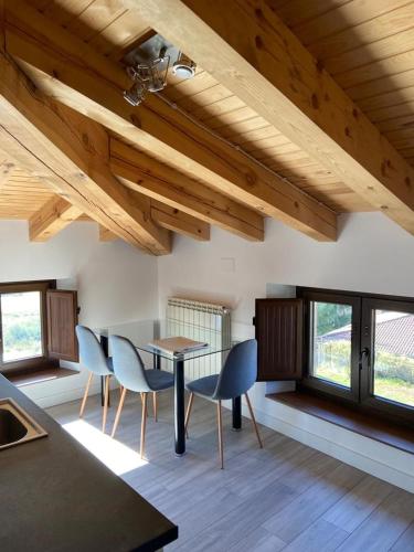 a dining room with a table and chairs and windows at Apartamentos Rurales La Plaza 2 in Duruelo de la Sierra