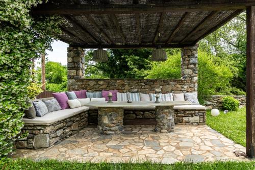 a stone pergola with a bench in a yard at Mountain's Secret in Mouresi