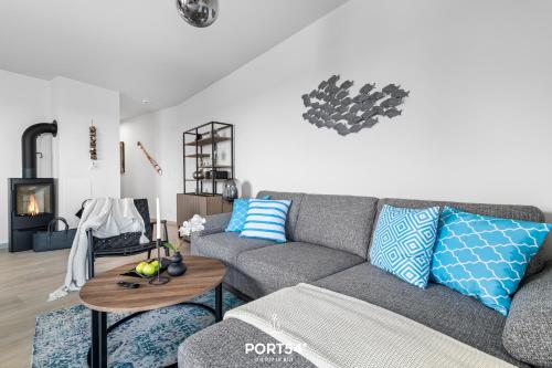 a living room with a gray couch and a table at Hafenglück in Olpenitz