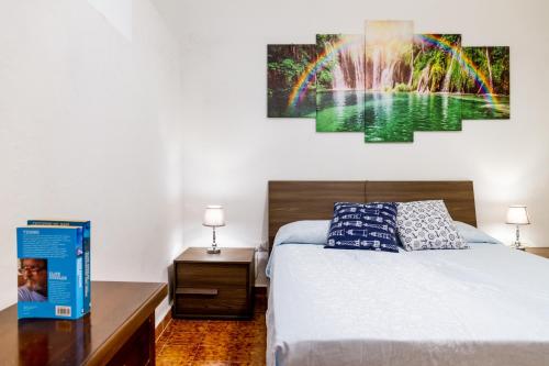 a bedroom with a bed and a painting on the wall at Casa la Fortezza in Porto Santo Stefano