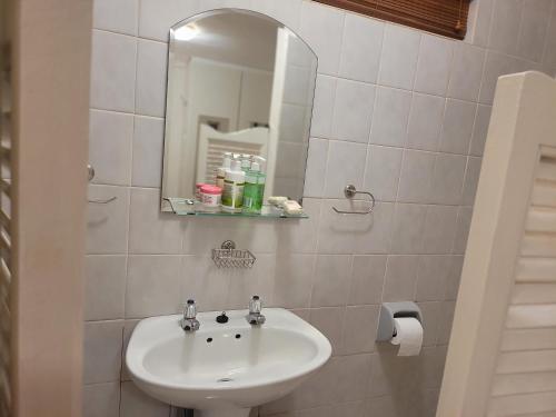 a white bathroom with a sink and a mirror at 147@ Simon Bekker Kosmos in Hartbeespoort
