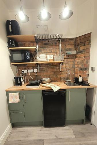 cocina con encimera con fregadero y encimera en Sunnyside Studio Apartment en Llandrindod Wells