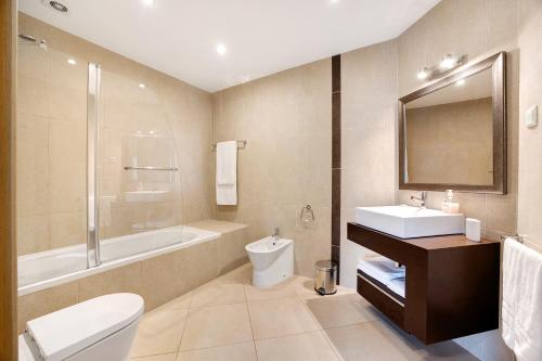 ein Badezimmer mit einem Waschbecken, einer Badewanne und einem WC in der Unterkunft Tourismer C in Lagos