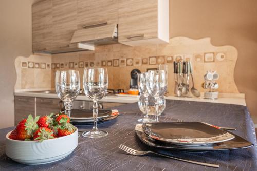 a table with plates and glasses and strawberries in a kitchen at Casa a schiera Budoni in Budoni