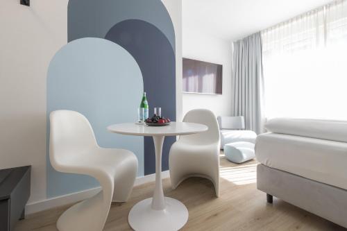 uma sala de estar com uma mesa branca e cadeiras em zzzpace Smart-Hotel Bielefeld Zentrum em Bielefeld