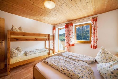 a bedroom with two beds and a bunk bed at Egarthof Ferienwohnung Arnika in Moso