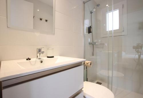 ein weißes Badezimmer mit Waschbecken und Dusche in der Unterkunft Rieres in Port de Pollença